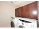 Convenient laundry area with a modern washer and dryer set and upper storage cabinets at 1920 E Manzanita Dr, Phoenix, AZ 85020