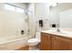 Bathroom with a shower-tub combo, neutral tile surround, and a single-sink wooden vanity at 19217 N Casa Blanca Way, Surprise, AZ 85387