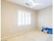 This light-filled bedroom has neutral carpet, a ceiling fan, plantation shutters and an electrical outlet at 19217 N Casa Blanca Way, Surprise, AZ 85387