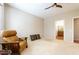 Large bedroom with a ceiling fan, neutral carpet, and a door leading to the en-suite bathroom at 19217 N Casa Blanca Way, Surprise, AZ 85387