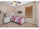 Cozy bedroom with a whimsical design, featuring a twin bed, nightstand, ceiling fan, and wood-look blinds at 1998 S Starling Dr, Gilbert, AZ 85295