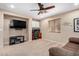 Neutral bedroom featuring built-in cabinets above a wooden desk, a TV set, and a dark ceiling fan at 1998 S Starling Dr, Gilbert, AZ 85295