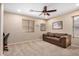 Neutral bedroom featuring tan walls, a ceiling fan, a cozy couch and natural light at 1998 S Starling Dr, Gilbert, AZ 85295