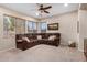 The open living room showcases a large sofa, a ceiling fan, and a view of the outdoor greenery at 1998 S Starling Dr, Gilbert, AZ 85295