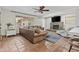 Cozy living room with leather sofa, stone fireplace, ceiling fan and terracotta tile flooring at 2007 S El Camino Dr, Tempe, AZ 85282