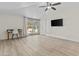 Minimalist living room with light wood floors, ceiling fan, TV and sliding doors at 2007 S El Camino Dr, Tempe, AZ 85282