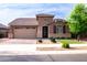 Charming single-story home showcasing a well-manicured front yard and inviting two-car garage at 20471 E Carriage Way, Queen Creek, AZ 85142