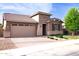 Inviting front exterior with a two-car garage and beautifully landscaped front yard under a blue sky at 20471 E Carriage Way, Queen Creek, AZ 85142