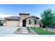 Charming single-story home featuring desert landscaping, a two-car garage, and a welcoming front entry at 20471 E Carriage Way, Queen Creek, AZ 85142