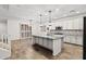 Spacious kitchen with white cabinets, granite countertops, a large kitchen island, and wood-look tile flooring at 21195 W Coronado Rd, Buckeye, AZ 85396