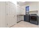 Laundry room includes modern washer and dryer, along with a utility sink and cabinets at 21195 W Coronado Rd, Buckeye, AZ 85396