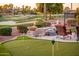 Backyard featuring putting green, fire bowls, and tranquil water feature with views of the golf course at 22020 N San Ramon Dr, Sun City West, AZ 85375