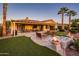 Outdoor patio with fire features, seating area, putting green and lush landscaping, perfect for entertaining at 22020 N San Ramon Dr, Sun City West, AZ 85375