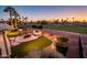 Outdoor living space with a putting green, fire pit, and views of the golf course at 22020 N San Ramon Dr, Sun City West, AZ 85375