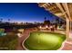 Outdoor putting green, fire bowls, and a covered patio overlooking a pristine golf course at 22020 N San Ramon Dr, Sun City West, AZ 85375