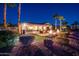 Lush backyard featuring a covered patio, fire bowls, and meticulously manicured landscaping and lawn at 22020 N San Ramon Dr, Sun City West, AZ 85375