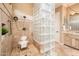 Bathroom showcasing a glass block partition, tiled shower, and a vanity with neutral countertops at 22020 N San Ramon Dr, Sun City West, AZ 85375