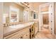 Bathroom featuring a double sink vanity, decorative mirror, and a tile backsplash at 22020 N San Ramon Dr, Sun City West, AZ 85375