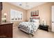 Bedroom featuring a wrought iron bed, neutral walls, and plantation shutters at 22020 N San Ramon Dr, Sun City West, AZ 85375