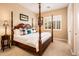 Bedroom featuring a four-poster bed, neutral carpet, and plantation shutters at 22020 N San Ramon Dr, Sun City West, AZ 85375