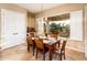 Dining area featuring a wooden table, six chairs, and a view of the landscaped backyard at 22020 N San Ramon Dr, Sun City West, AZ 85375