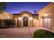 Stylish single-story home featuring a gated entrance with an arched doorway and manicured landscaping at 22020 N San Ramon Dr, Sun City West, AZ 85375