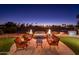 Outdoor seating around a fire pit adds drama to this golf course backyard at 22020 N San Ramon Dr, Sun City West, AZ 85375