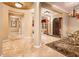 Spacious foyer with travertine floors, decorative columns, and views of the formal dining area at 22020 N San Ramon Dr, Sun City West, AZ 85375