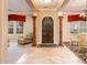 Elegant foyer with travertine floors, decorative columns, and an arched wood front door at 22020 N San Ramon Dr, Sun City West, AZ 85375