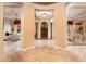 Spacious foyer featuring travertine floors, decorative columns, and an arched front door at 22020 N San Ramon Dr, Sun City West, AZ 85375