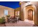 Charming front entrance with a beautiful arched wood door and outdoor seating area at 22020 N San Ramon Dr, Sun City West, AZ 85375