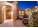 Inviting front entrance with an arched wood door and cozy outdoor seating area at 22020 N San Ramon Dr, Sun City West, AZ 85375