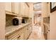 Hallway with granite countertops and many cabinets and view of the dining room beyond at 22020 N San Ramon Dr, Sun City West, AZ 85375