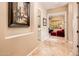 Hallway featuring neutral walls, tile flooring, and views into laundry room and office at 22020 N San Ramon Dr, Sun City West, AZ 85375