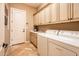 Functional laundry room boasts ample cabinet space, a utility sink, and a convenient washer and dryer at 22020 N San Ramon Dr, Sun City West, AZ 85375