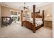 Spacious main bedroom with a four-poster bed, patio access, and golf course views at 22020 N San Ramon Dr, Sun City West, AZ 85375