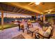 An expansive covered patio offers a tranquil golf course view with an outdoor putting green and a firepit at 22020 N San Ramon Dr, Sun City West, AZ 85375