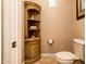 Cozy powder room with a corner cabinet, toilet, and beige walls at 22020 N San Ramon Dr, Sun City West, AZ 85375