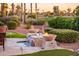 Backyard water feature with fire bowls and lush landscaping, with a glimpse of the golf course at 22020 N San Ramon Dr, Sun City West, AZ 85375