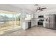 Modern white kitchen with stainless steel appliances, white cabinets, and sliding glass door to the backyard at 2336 W Plata Ave, Mesa, AZ 85202