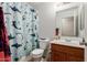 Cozy bathroom with a playful shark-themed shower curtain and a classic vanity at 23430 W Pima St, Buckeye, AZ 85326