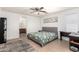 Calm main bedroom showcasing a queen-sized bed, tile floors, and an ensuite bathroom entrance at 23430 W Pima St, Buckeye, AZ 85326