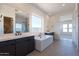 Modern bathroom with soaking tub, dual vanities, and large window providing natural light at 24066 S 218Th Pl, Queen Creek, AZ 85142