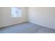 An empty bedroom with neutral carpet, white walls, and a window offering natural light at 24066 S 218Th Pl, Queen Creek, AZ 85142