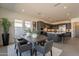 Dining room with a wooden table, gray chairs, neutral rug, and a view of the modern kitchen and its stainless appliances at 24066 S 218Th Pl, Queen Creek, AZ 85142