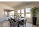 Bright dining room features a modern table, gray chairs, and natural light from large windows and sliding doors at 24066 S 218Th Pl, Queen Creek, AZ 85142