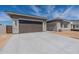 Charming home exterior with a two-car garage, stone accents, and a paved driveway at 24066 S 218Th Pl, Queen Creek, AZ 85142