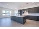 Contemporary kitchen featuring a large island, dark cabinets, and stainless steel appliances for modern appeal at 24066 S 218Th Pl, Queen Creek, AZ 85142