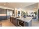 Modern kitchen showcasing stainless steel appliances, gray cabinetry, a large island, and an open layout to the living area at 24066 S 218Th Pl, Queen Creek, AZ 85142