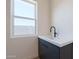 Bright laundry room featuring a modern sink with matte black faucet and base cabinets at 24066 S 218Th Pl, Queen Creek, AZ 85142